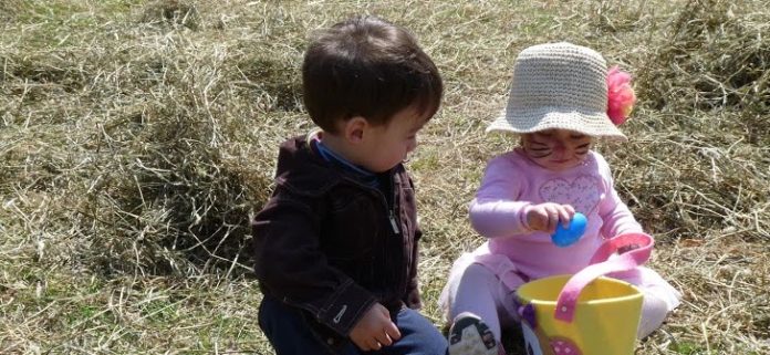 New friends 14-month old Dessa Wojcio and 17-month old Liam James Fasce contemplate the mystery of the egg at the Red Hook Easter Egg Scramble April 19 at the Linden Avenue Mid