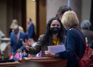 Assemblyperson Sarahana Shrestha speaks with a colleague on the floor of the Assembly.