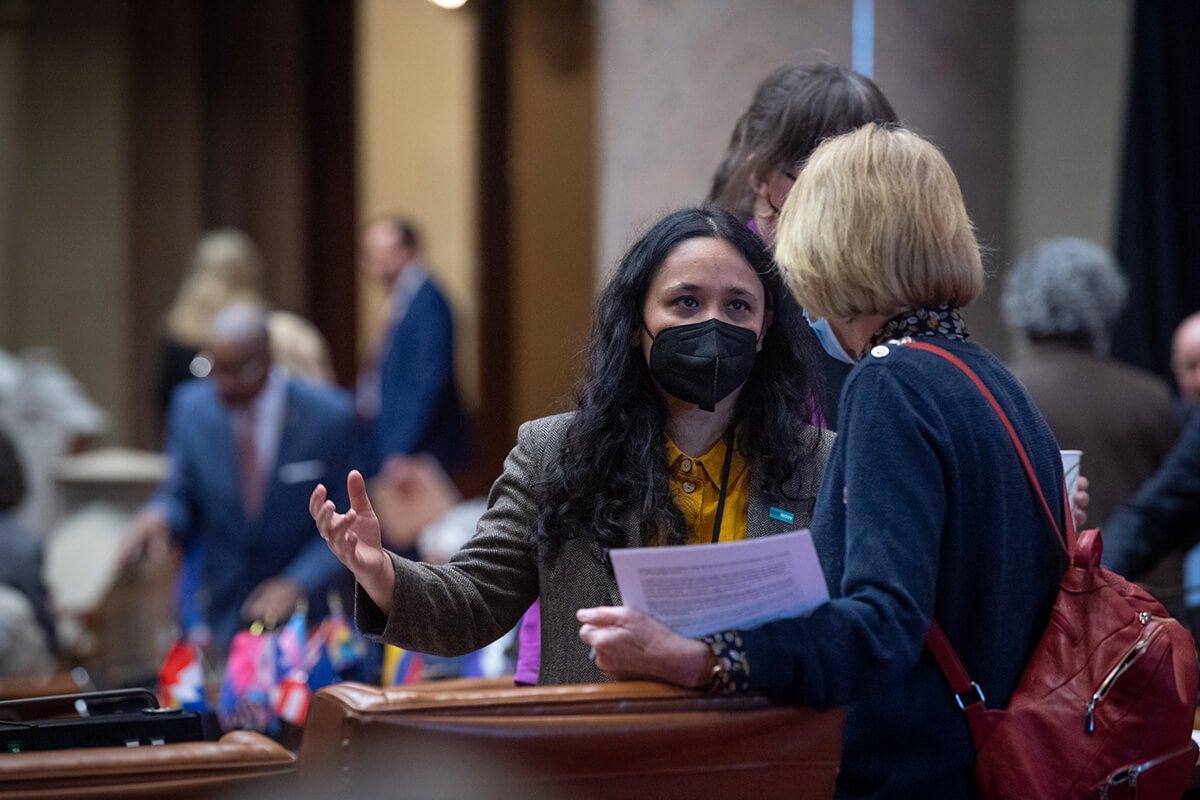 Assemblyperson Sarahana Shrestha speaks with a colleague on the floor of the Assembly.